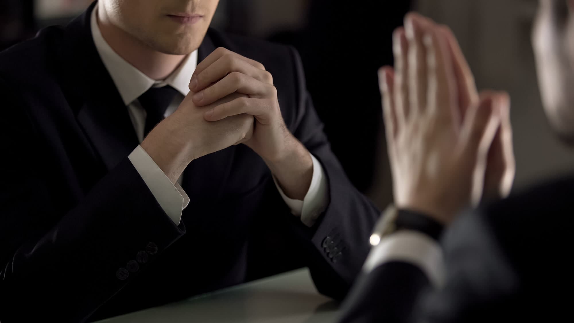 שני אנשי עסקים בחליפות יושבים זה מול זה במשא ומתן — רגולציה וליווי הליכי חקיקה