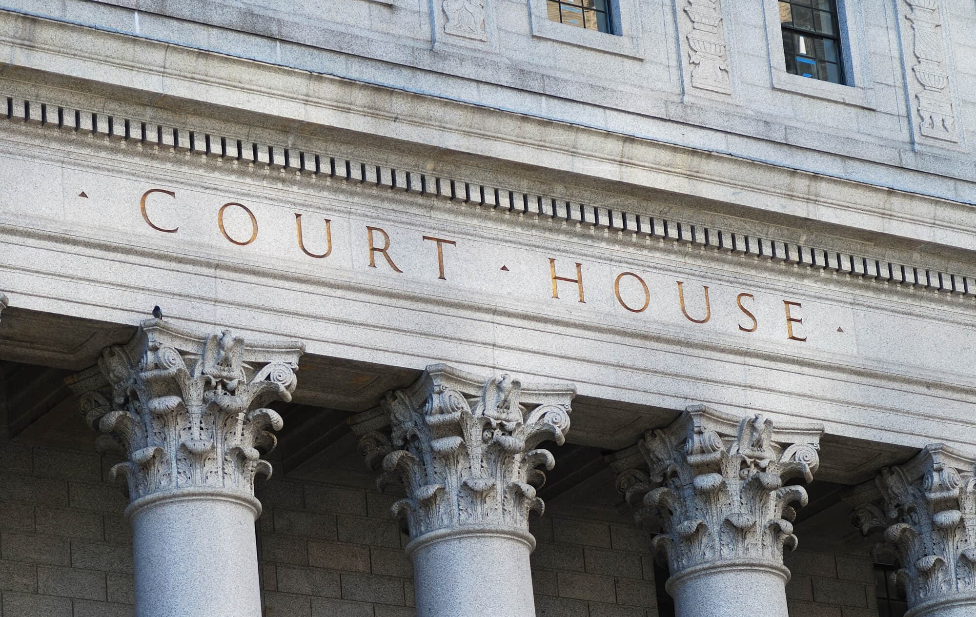 חזית מבנה בית משפט עם עמודי אבן וכיתוב Court House — חוות דעת מומחה בבית המשפט
